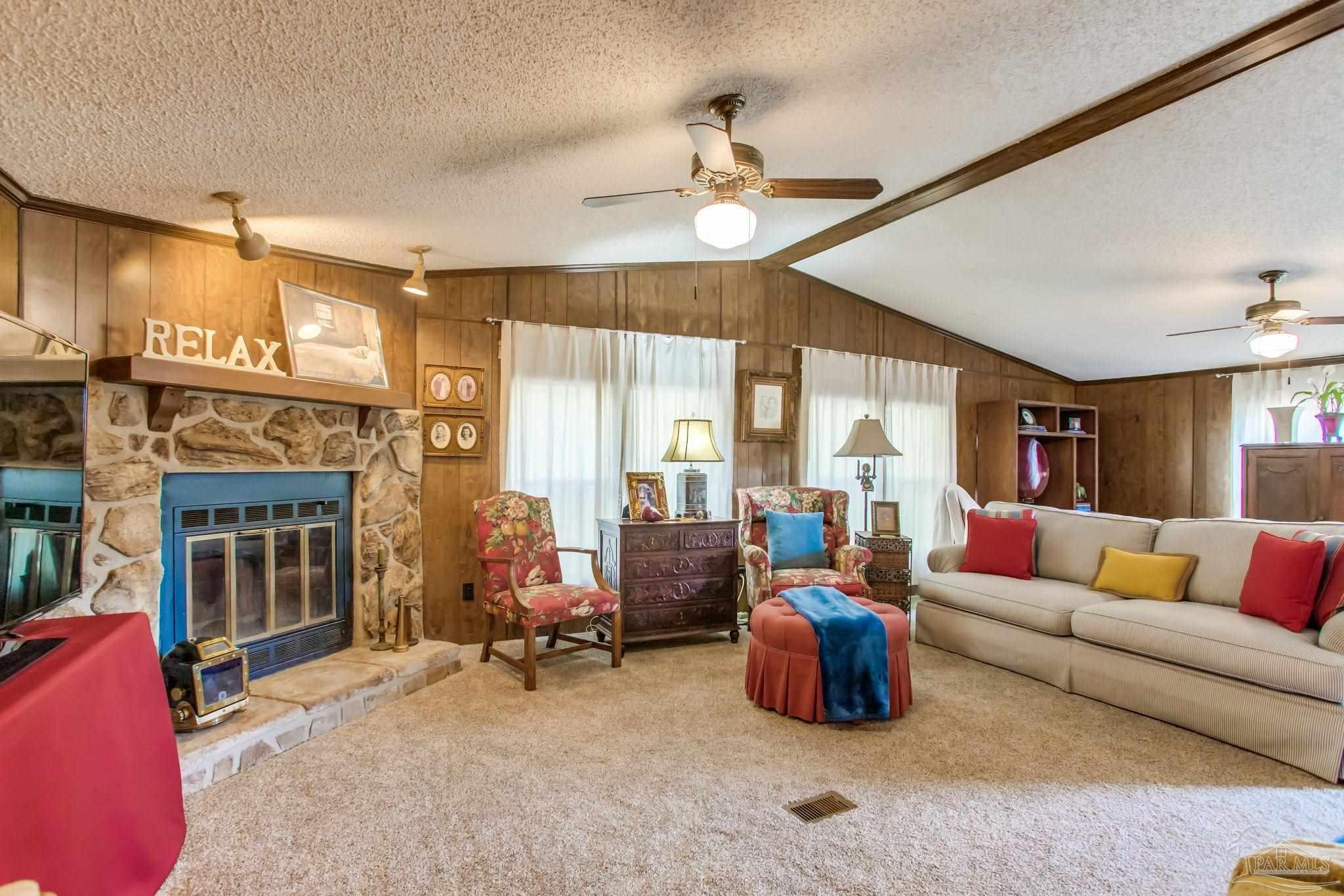 5150-5172 Siripon Road Milton, FL 32570 - Photo 27 of 54 a living room with furniture a fireplace and a chandelier