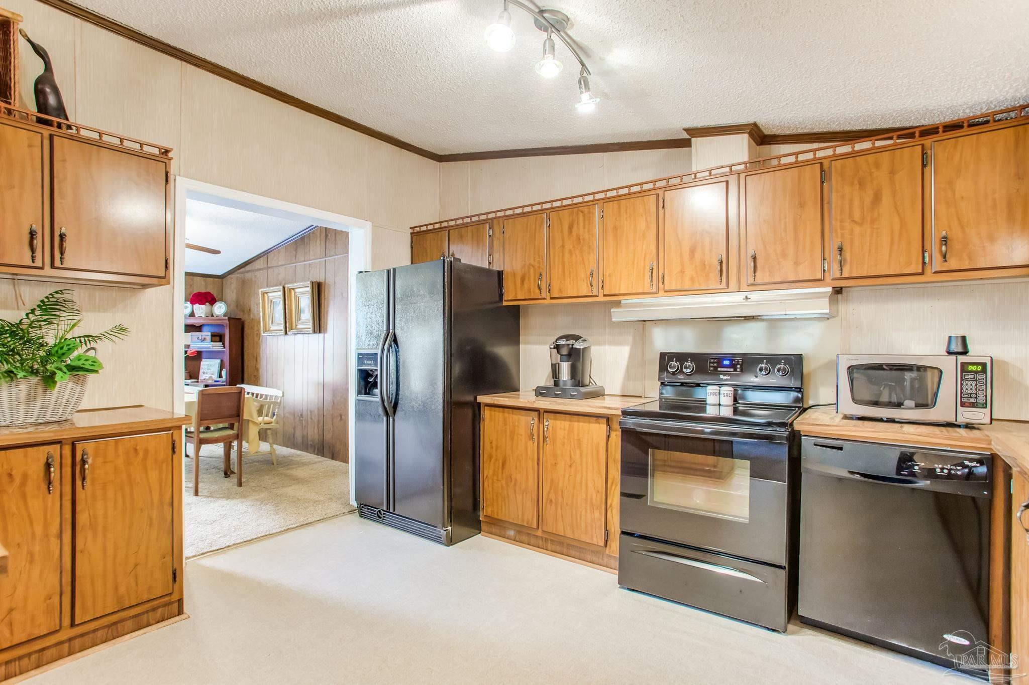 5150-5172 Siripon Road Milton, FL 32570 - Photo 31 of 54 a kitchen with stainless steel appliances granite countertop a refrigerator sink and cabinets