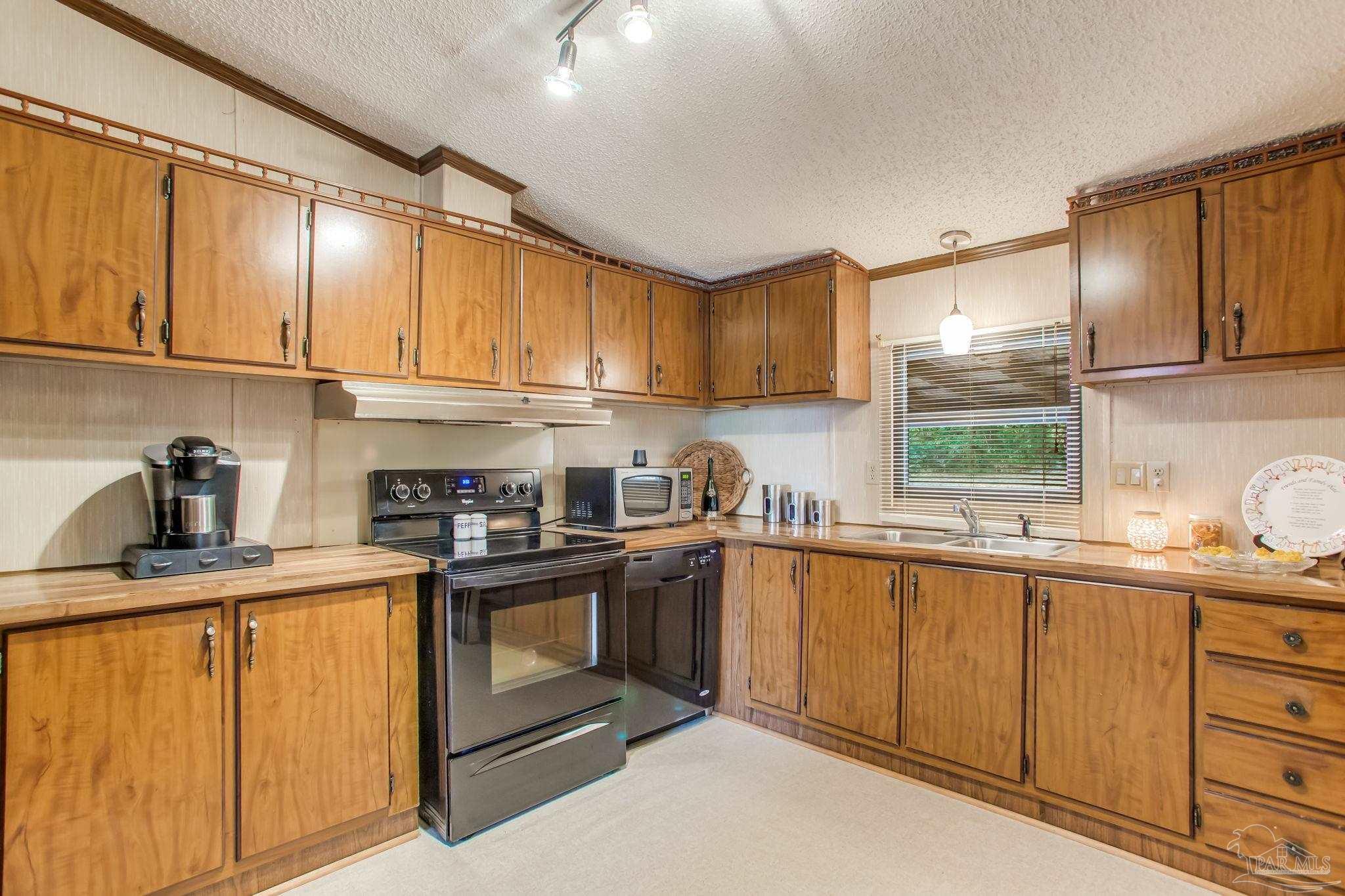 5150-5172 Siripon Road Milton, FL 32570 - Photo 32 of 54 a kitchen with stainless steel appliances granite countertop a sink a stove and cabinets
