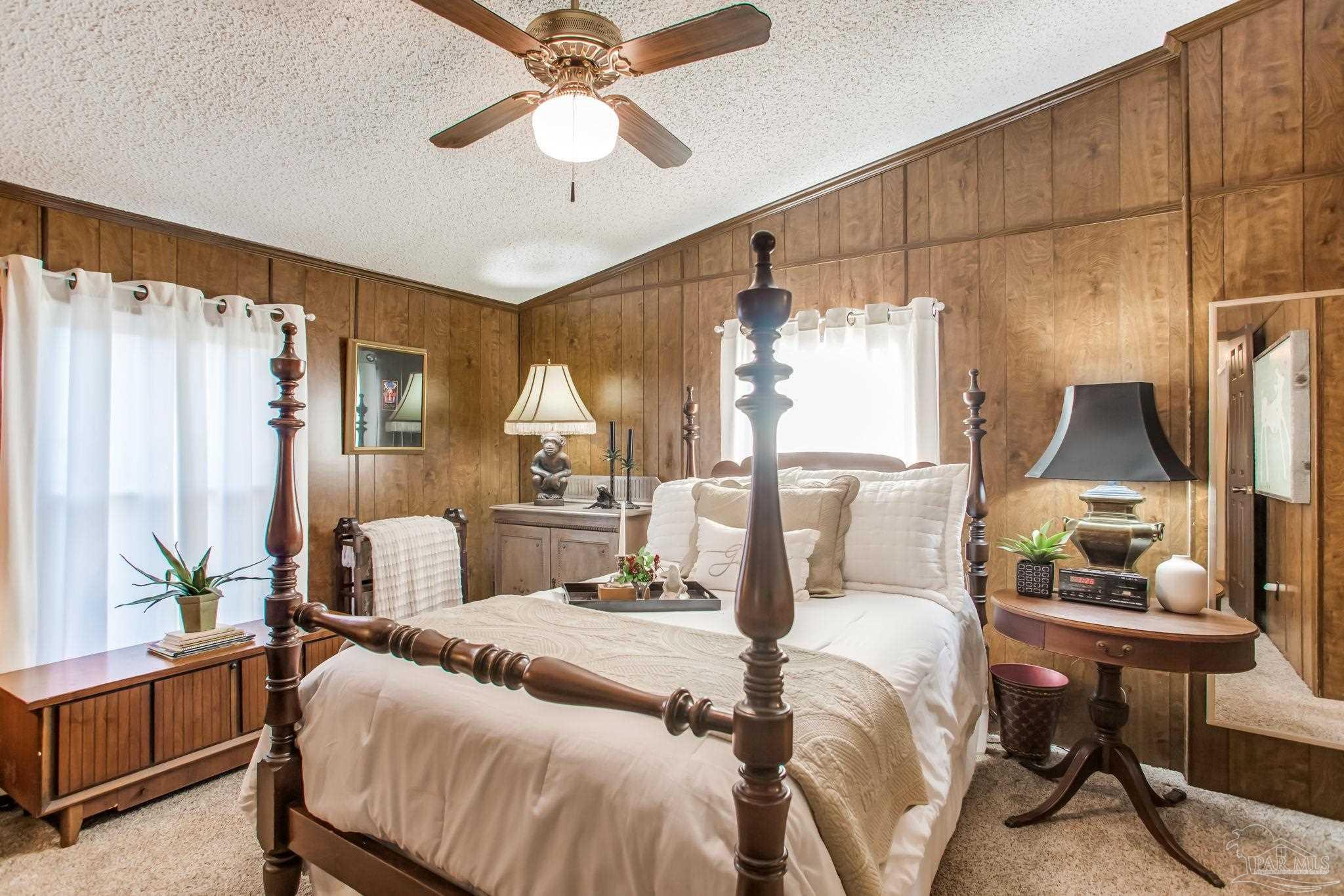 5150-5172 Siripon Road Milton, FL 32570 - Photo 35 of 54 a bedroom with a large bed and a chandelier
