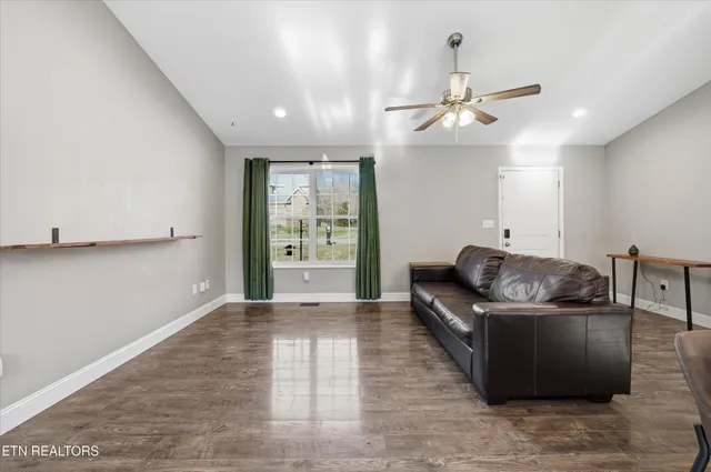 a living room with furniture and a ceiling fan