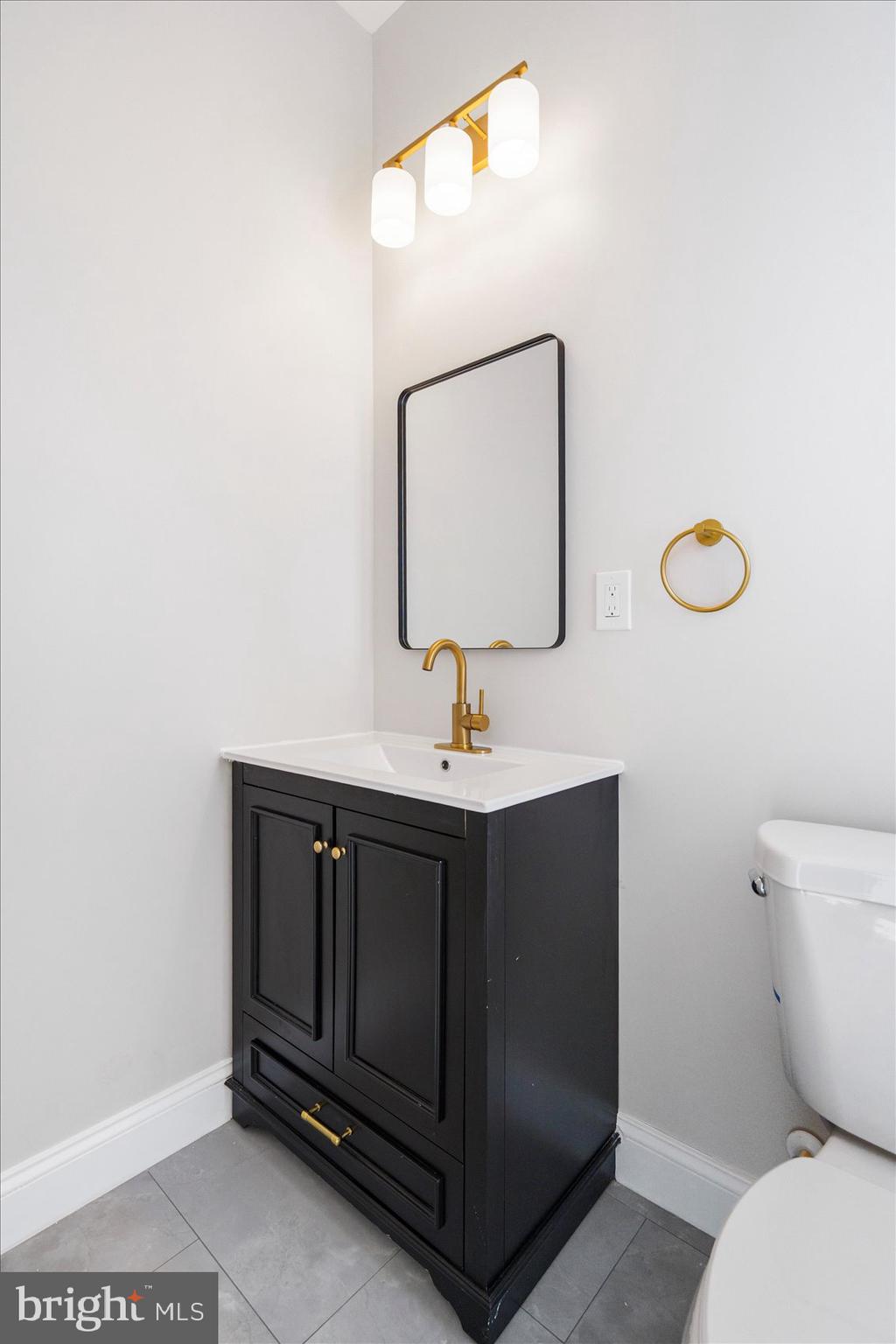 1415 East Lanvale Street Baltimore, MD 21213 - Photo 15 of 42 a bathroom with a toilet sink and mirror