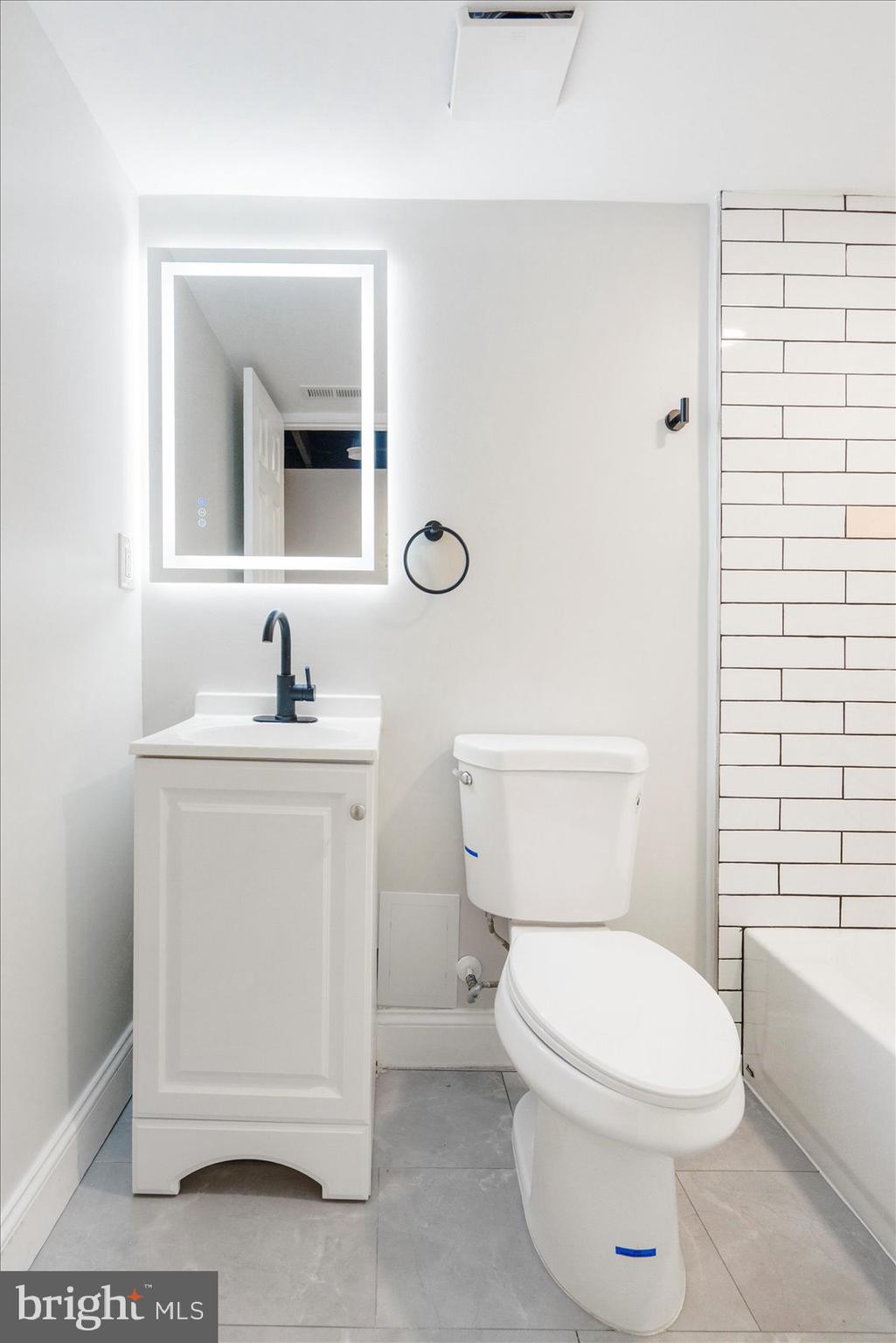 1415 East Lanvale Street Baltimore, MD 21213 - Photo 39 of 42 a white toilet sitting next to a bathroom sink