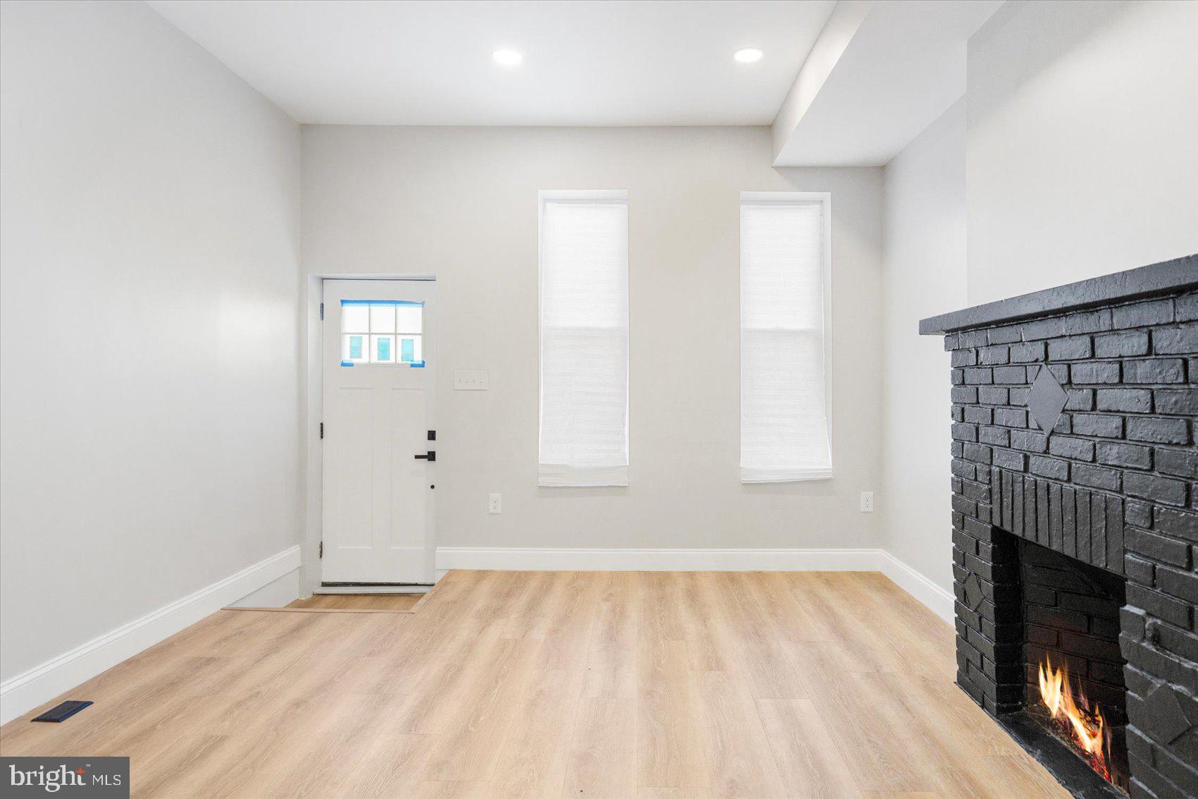 1415 East Lanvale Street Baltimore, MD 21213 - Photo 5 of 42 an empty room with windows and fireplace