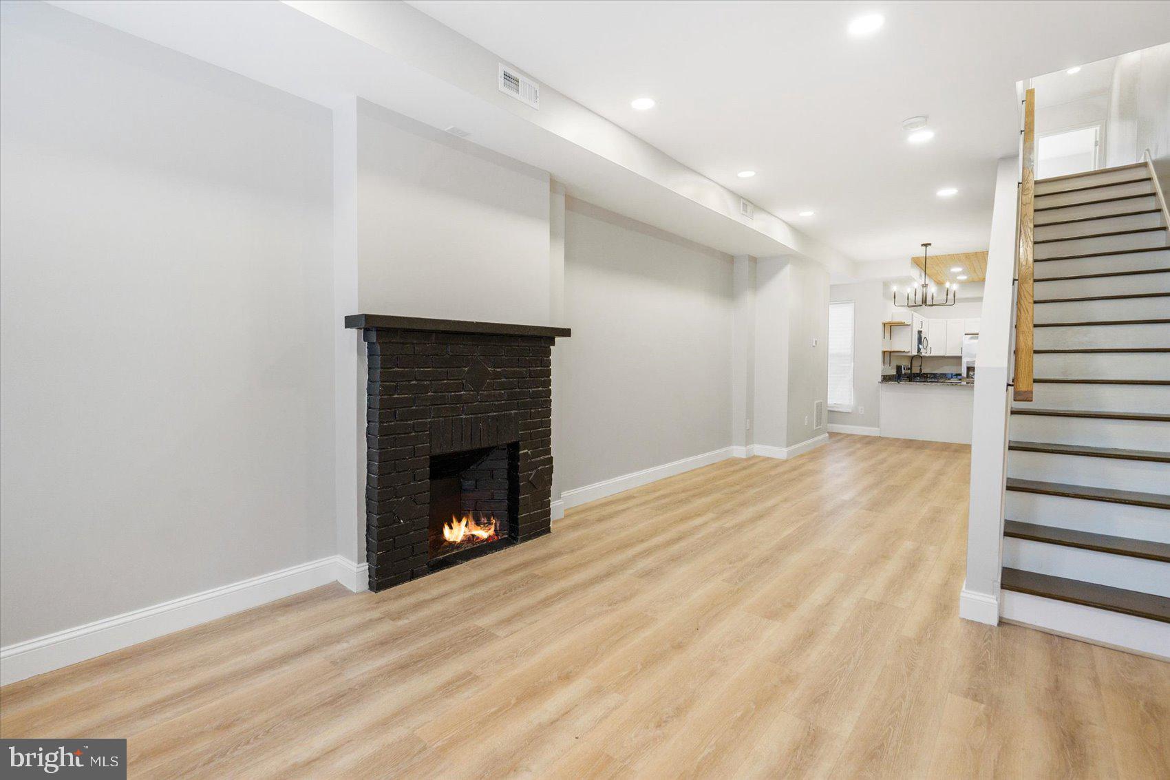 1415 East Lanvale Street Baltimore, MD 21213 - Photo 7 of 42 a view of a livingroom with wooden floor and a fireplace