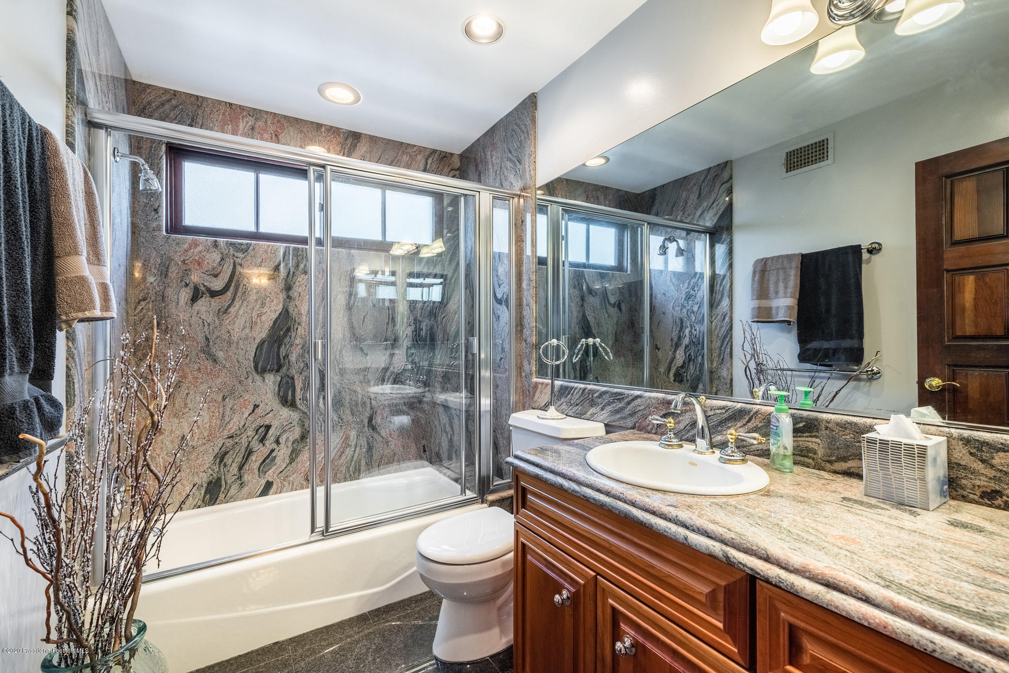 150 Sequoia Drive Pasadena, CA 91105 - Photo 37 of 53 a bathroom with a granite countertop sink a toilet a mirror a bathtub and shower