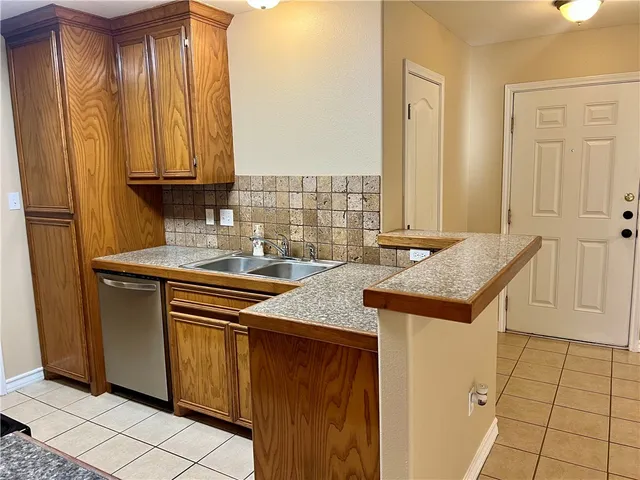 a view of a kitchen with granite countertop a sink and cabinets