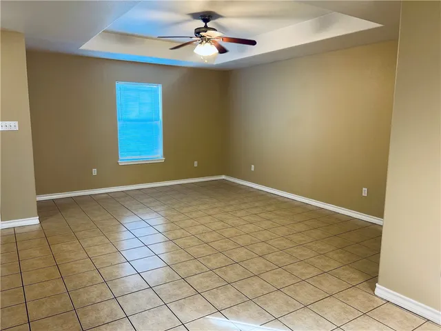 an empty room with windows and ceiling fan