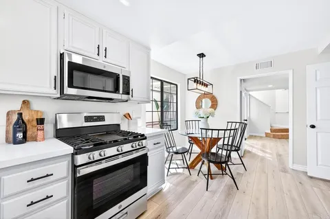 a kitchen with stainless steel appliances a stove a microwave and wooden floors