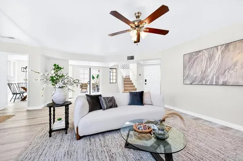 a living room with furniture and a wooden floor