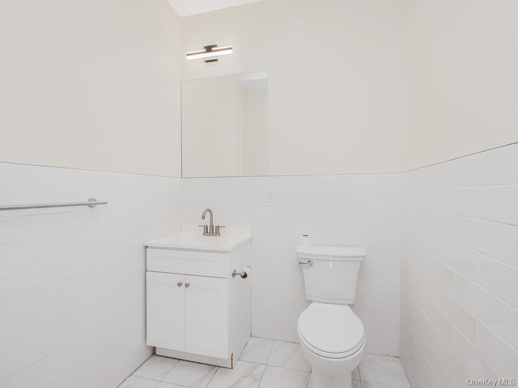 409 Warburton Avenue, Unit 5A Yonkers, NY 10701 - Photo 8 of 13 Bathroom with a wainscoted wall, tile walls, and vanity