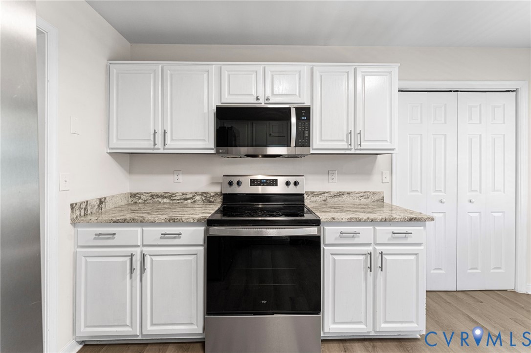 1146 Indian Valley Road Heathsville, VA 22473 - Photo 9 of 45 a kitchen with white cabinets and black appliances