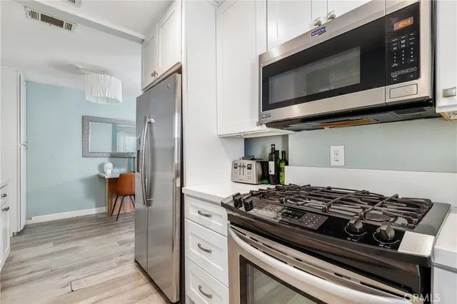 a kitchen with stainless steel appliances kitchen island a stove and a microwave
