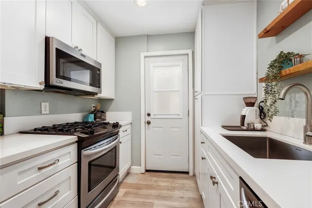 a kitchen with stainless steel appliances granite countertop a sink stove a microwave and cabinets