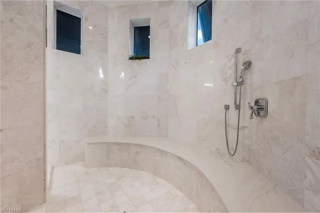 a bedroom with a bed lamp and a large window