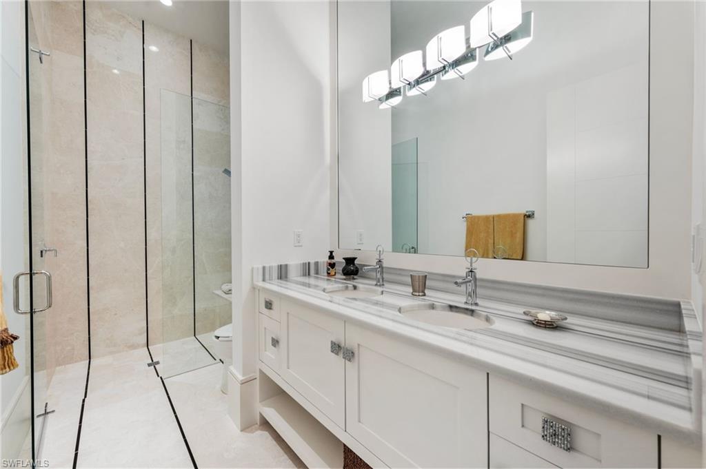 13851 Williston Way Naples, FL 34119 - Photo 23 of 50 a bathroom with a double vanity sink and a mirror