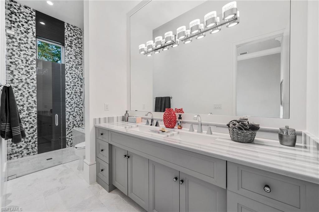 13851 Williston Way Naples, FL 34119 - Photo 25 of 50 a bathroom with a double vanity sink and a mirror