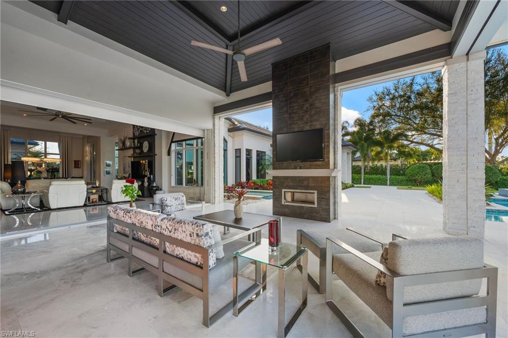 13851 Williston Way Naples, FL 34119 - Photo 32 of 50 a living room with fireplace furniture and a floor to ceiling window