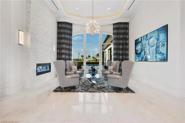 a living room with furniture a chandelier and a large mirror
