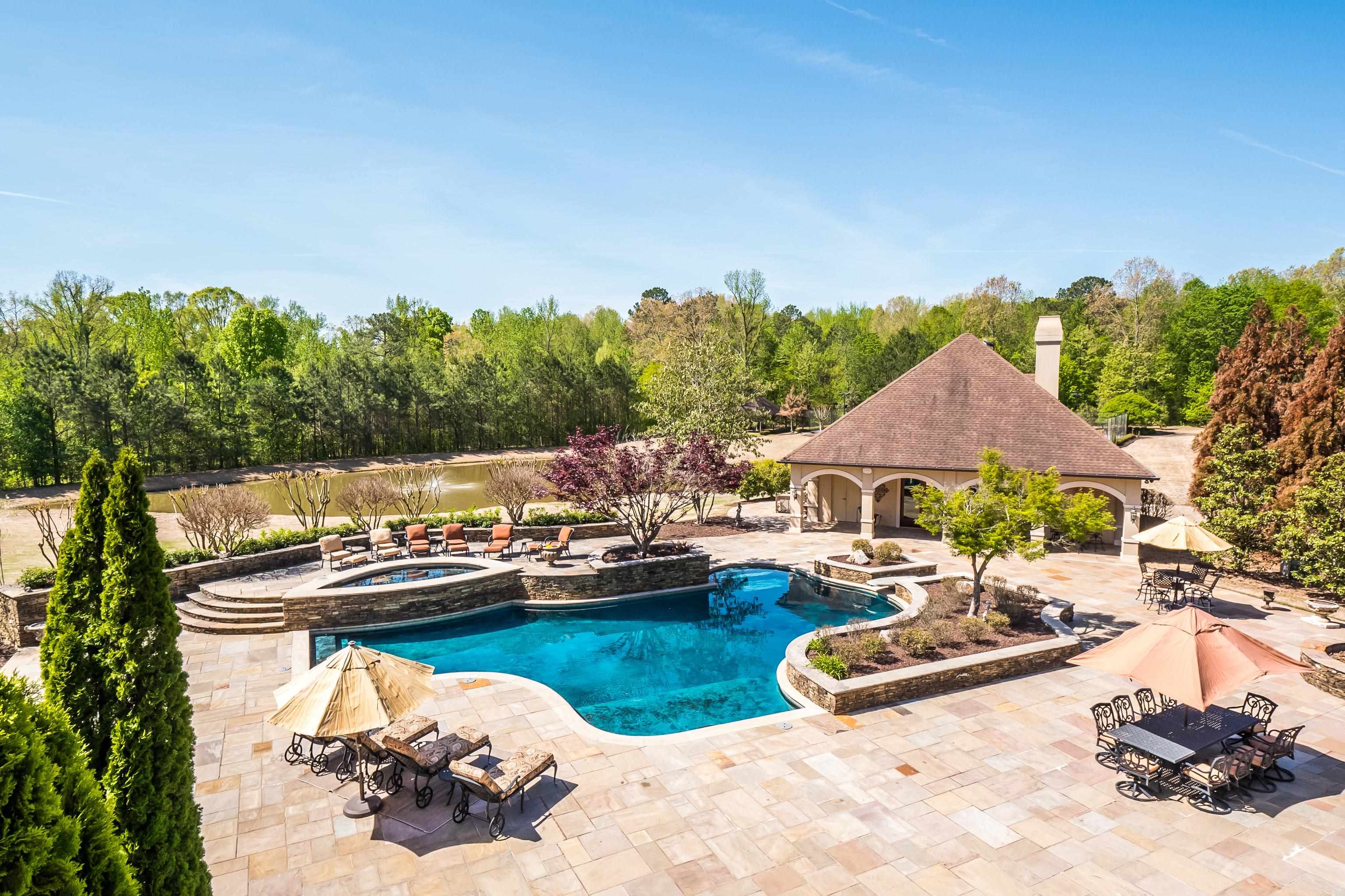 2000 Patrick Drive Corinth, MS 38834 - Photo 22 of 25 a view of a lake with couches chairs and swimming pool