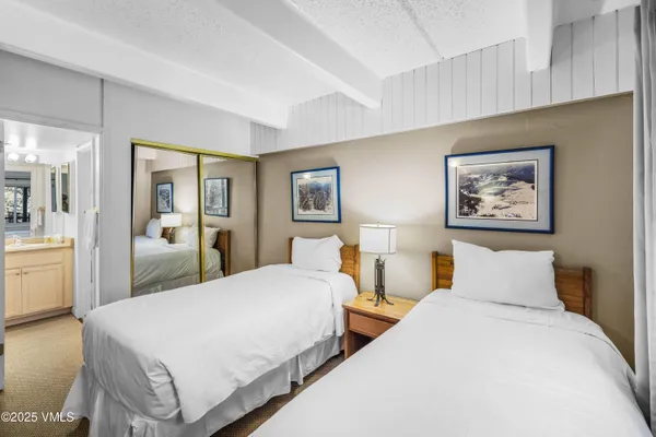 a bedroom with two beds and a large mirror