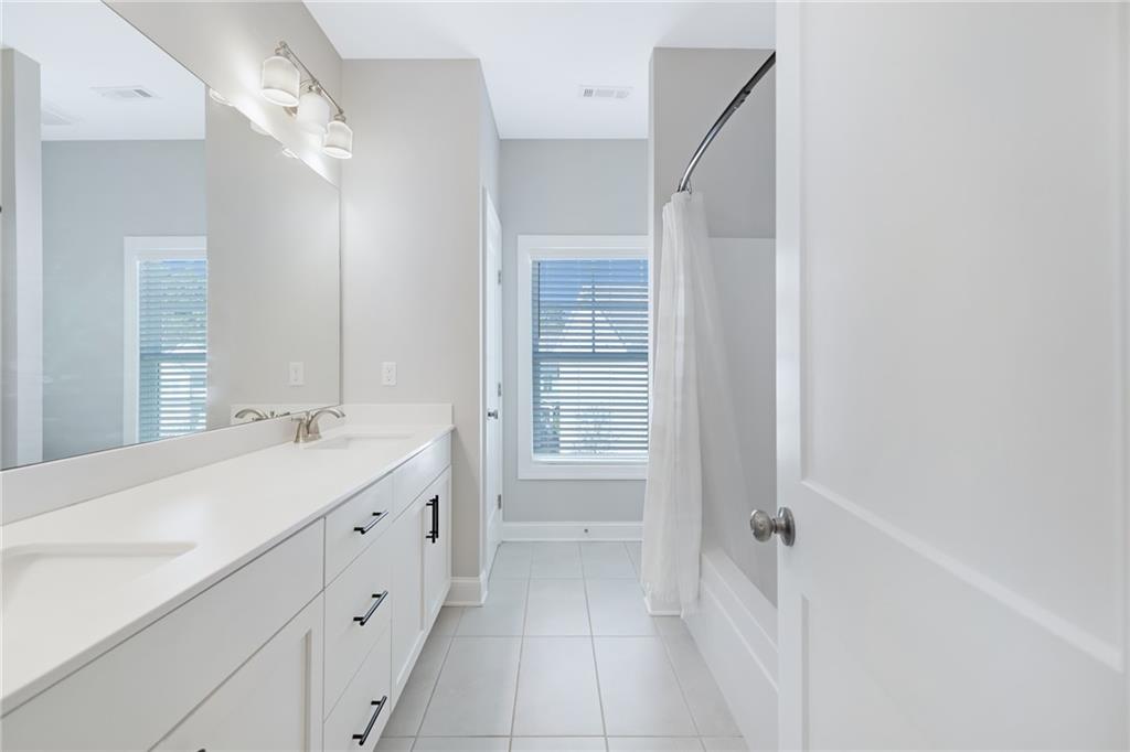 1859 Commons Place Atlanta, GA 30318 - Photo 36 of 53 a bathroom with a double vanity sink and mirror with shower