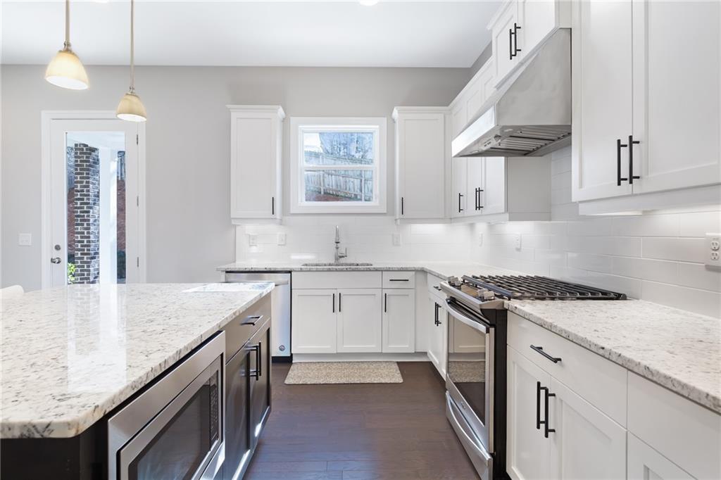 1859 Commons Place Atlanta, GA 30318 - Photo 6 of 53 a kitchen with granite countertop a sink stove and cabinets