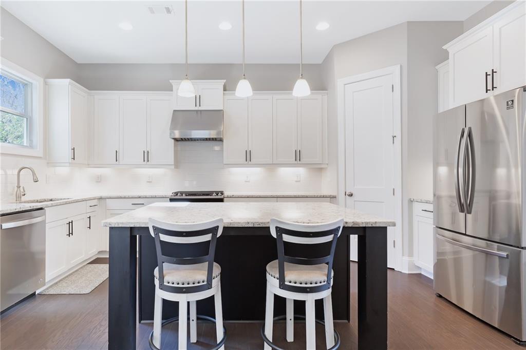 1859 Commons Place Atlanta, GA 30318 - Photo 7 of 53 a kitchen with stainless steel appliances a white stove top oven and white cabinets