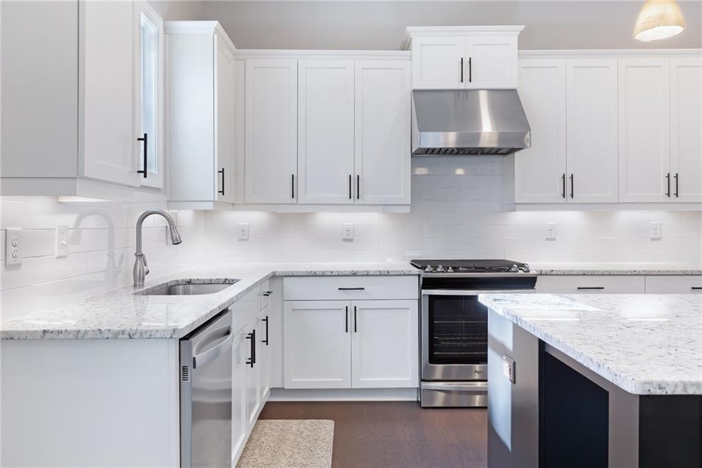 1859 Commons Place Atlanta, GA 30318 - Photo 8 of 53 a kitchen with granite countertop a sink stove and cabinets