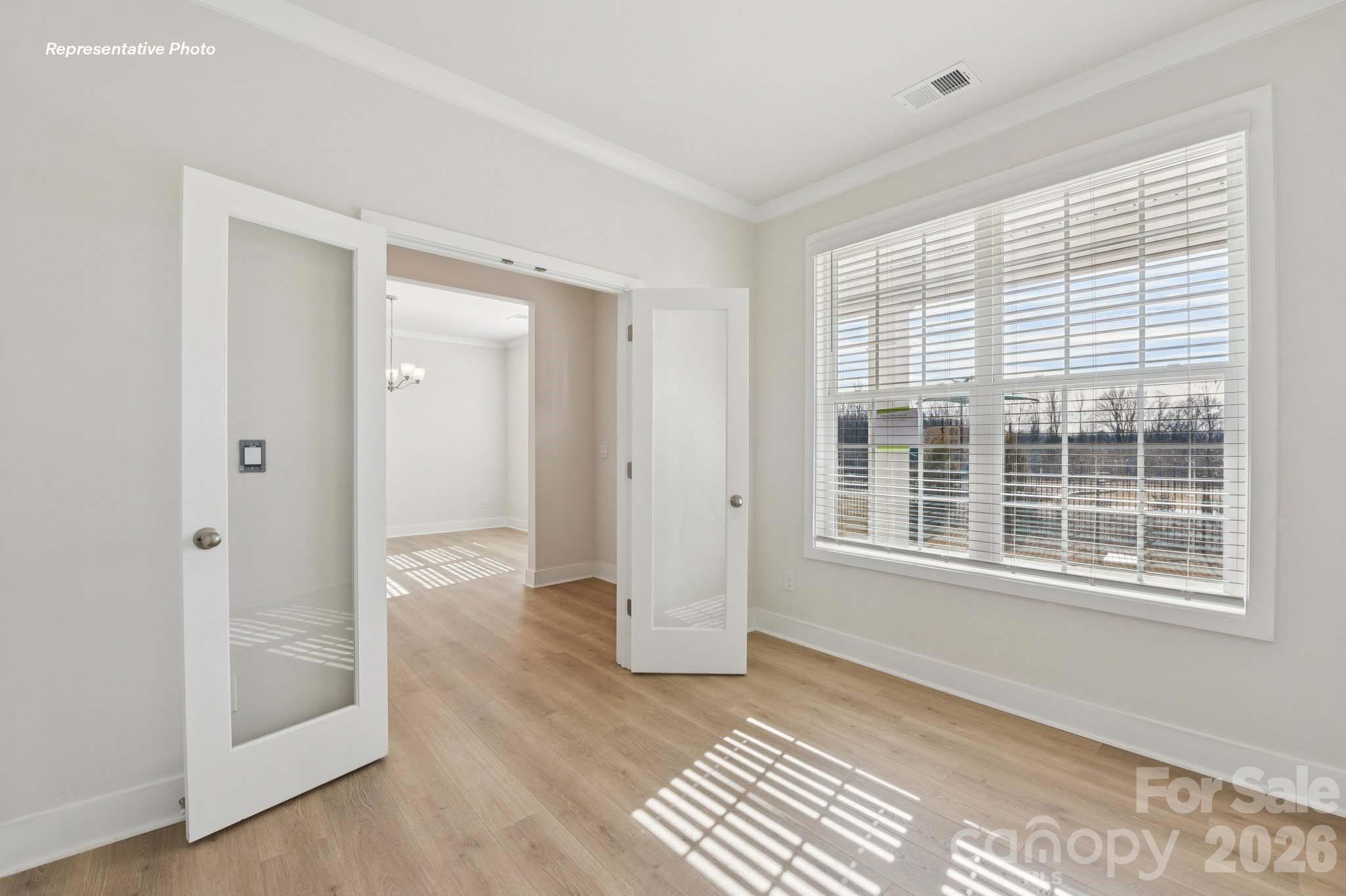 8905 Overhill Road Huntersville, NC 28078 - Photo 4 of 30 an empty room with wooden floor and windows