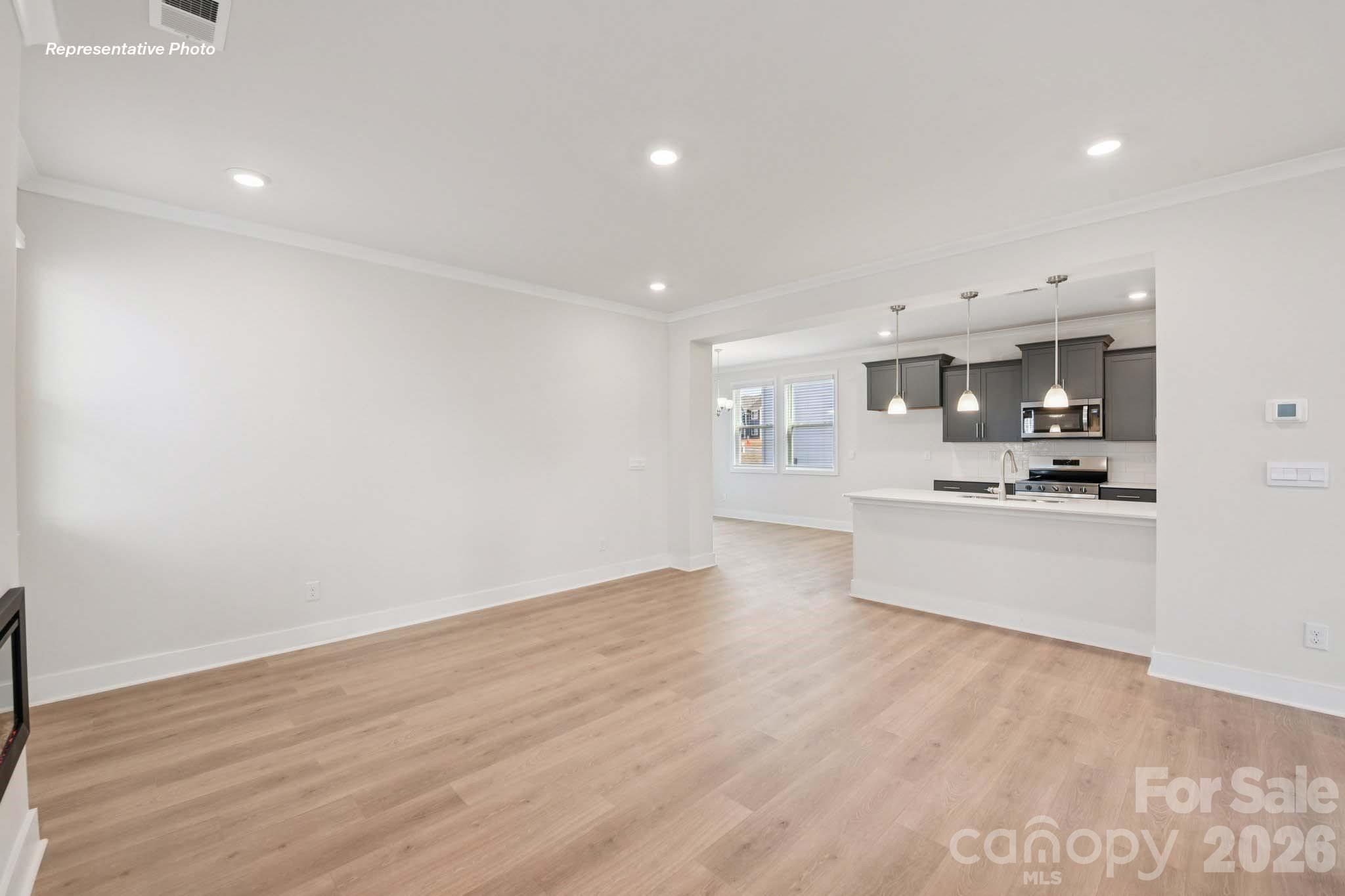 8905 Overhill Road Huntersville, NC 28078 - Photo 9 of 30 a large kitchen with stainless steel appliances a large counter top and a wooden floor
