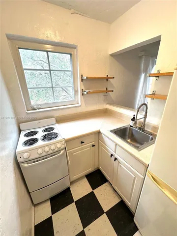 a kitchen with a sink stove and white cabinets