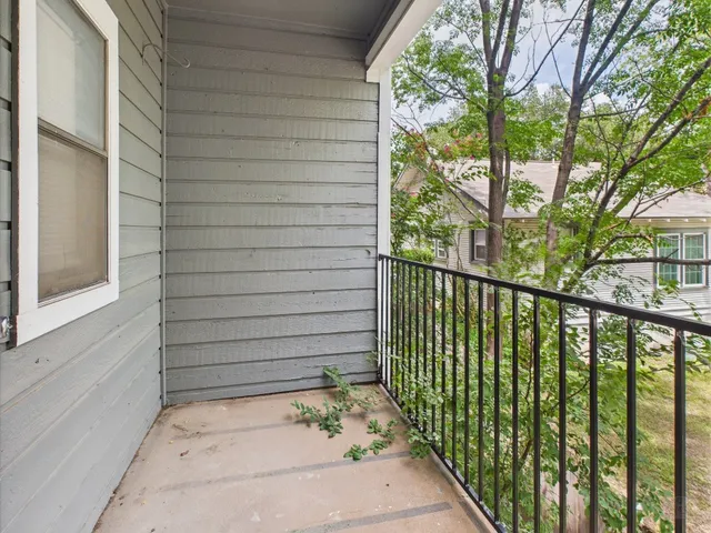 a view of a porch with a floor to ceiling window and garden