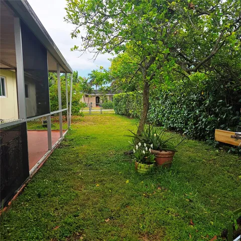 a backyard of a house with table and chairs a barbeque with wooden fence