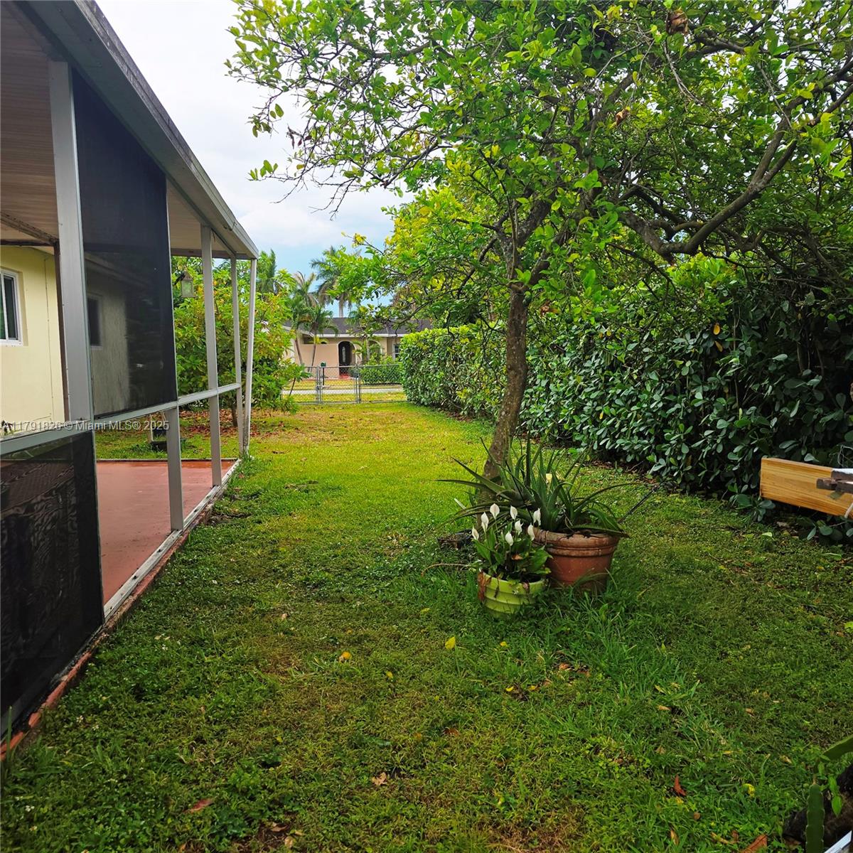 12900 Southwest 81st Street Miami, FL 33183 - Photo 16 of 19 a backyard of a house with table and chairs a barbeque with wooden fence