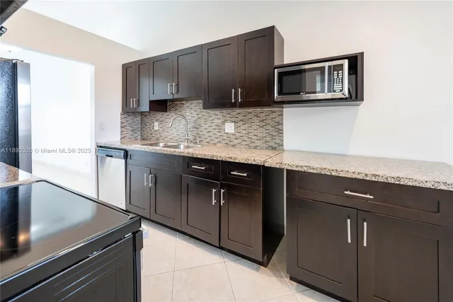 a kitchen with granite countertop cabinets stainless steel appliances and a sink
