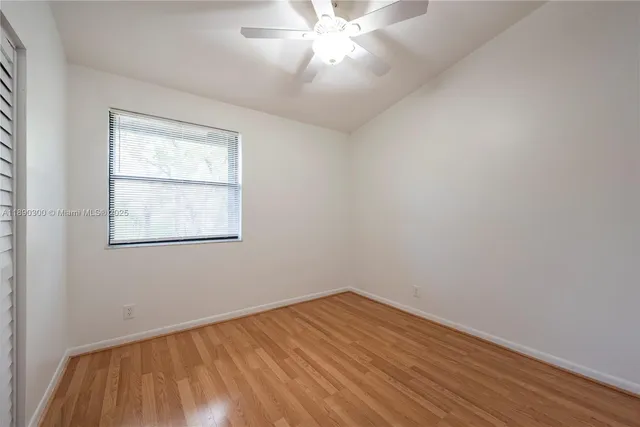 an empty room with a window and wooden floor