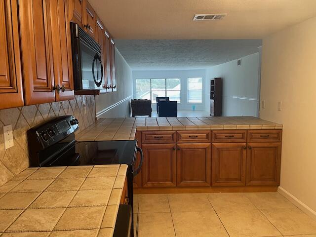 315 Tangle Run Boulevard, Unit 1023 Melbourne, FL 32940 - Photo 6 of 17 a kitchen with stainless steel appliances granite countertop a stove and cabinets