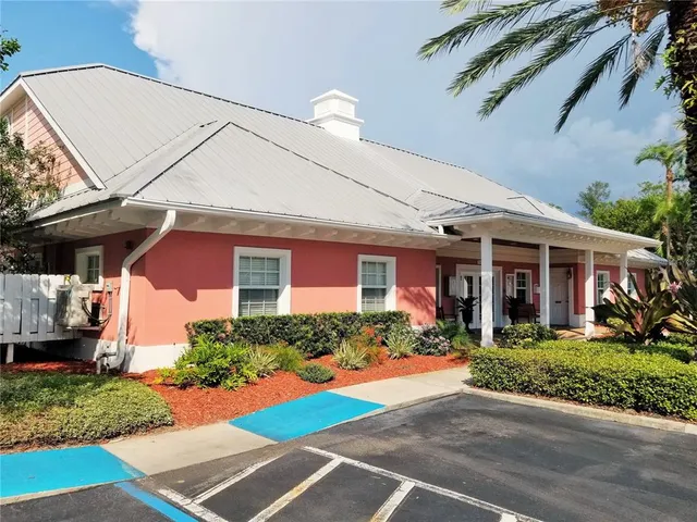 a front view of a building with palm trees