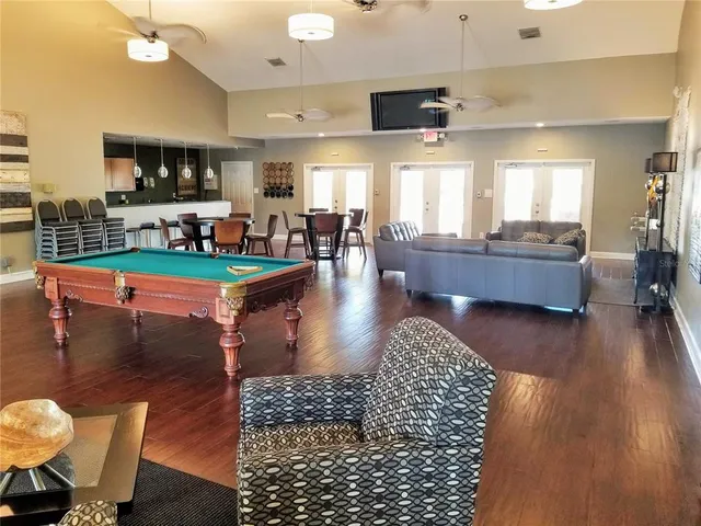 a living room with furniture wooden floor and a large window