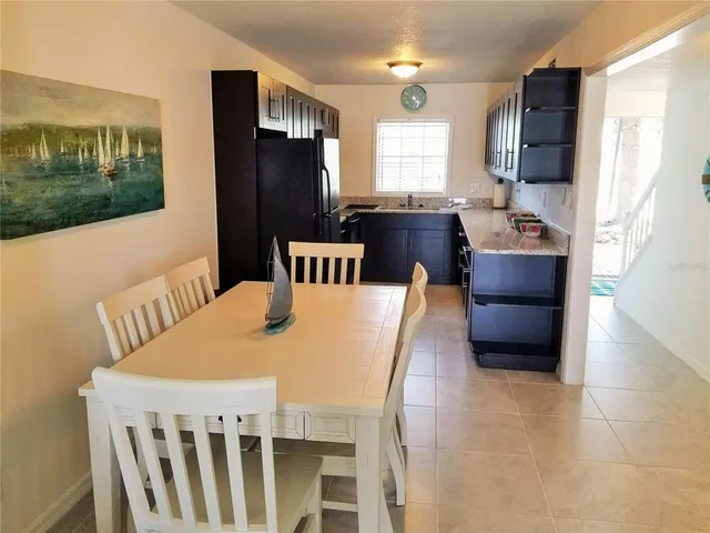 a kitchen with stainless steel appliances wooden floor dining table and chairs