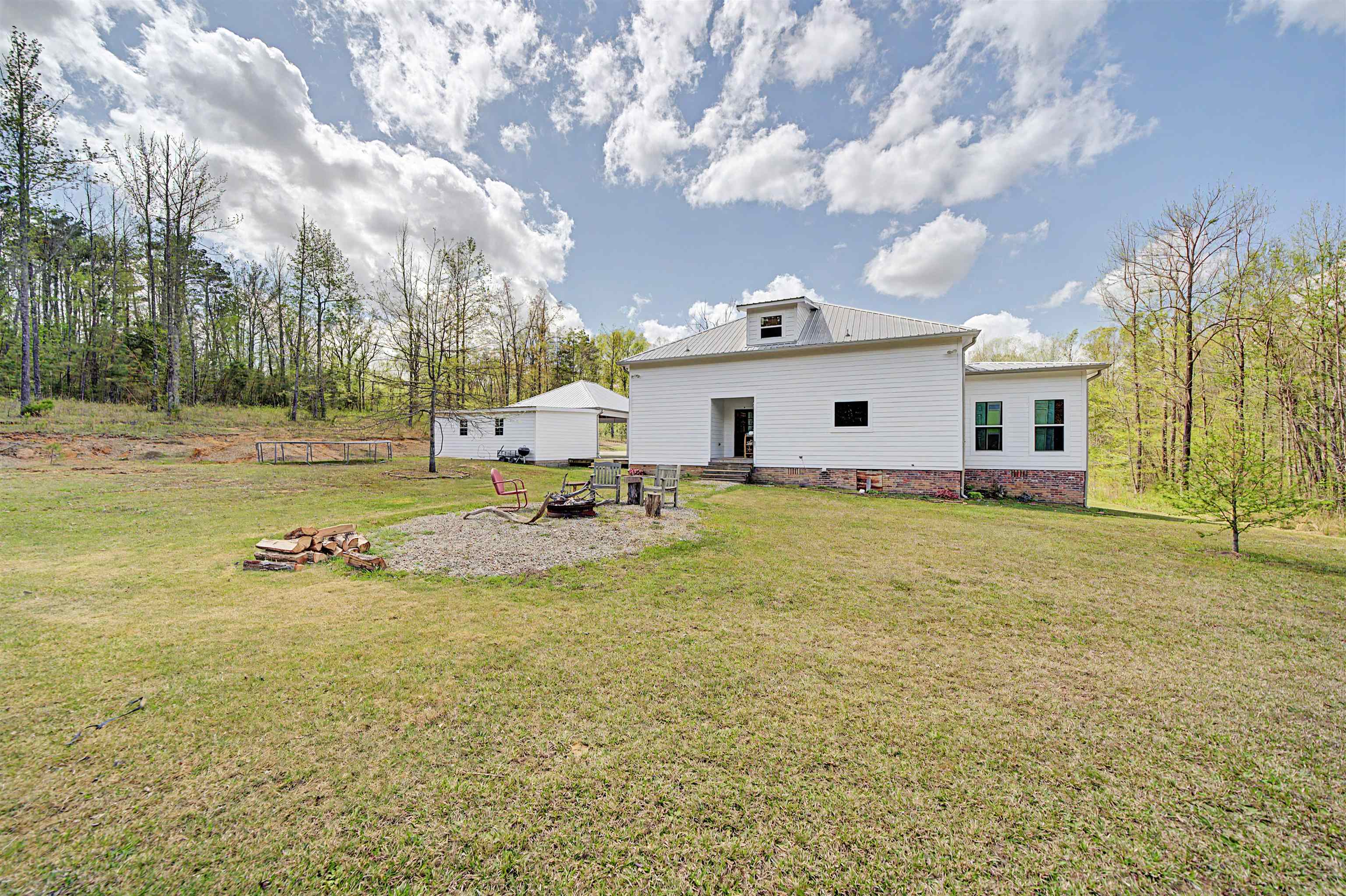 300 Grace Thomas Road Michie, TN 38357 - Photo 22 of 26 Rear view of property featuring a yard, a metal roof, an outdoor fire pit, and a patio