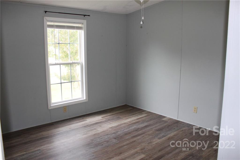 339 Dewitt Owens Road Rutherfordton, NC 28139 - Photo 16 of 48 an empty room with wooden floor and windows