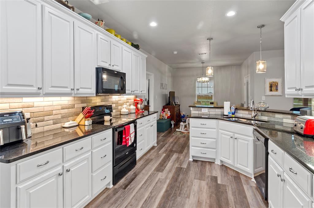 141 Walnut Street Paradise, TX 76073 - Photo 13 of 23 Kitchen featuring black appliances, dark stone countertops, pendant lighting, white cabinetry, and light wood-style floors