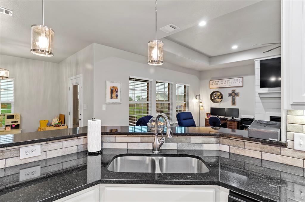 141 Walnut Street Paradise, TX 76073 - Photo 23 of 23 Kitchen featuring open floor plan, dark stone countertops, white cabinetry, a raised ceiling, and decorative light fixtures