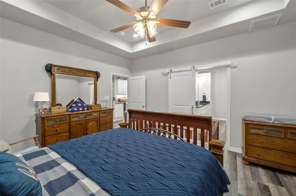 141 Walnut Street Paradise, TX 76073 - Photo 20 of 23 Bedroom featuring a tray ceiling, wood finished floors, and ceiling fan