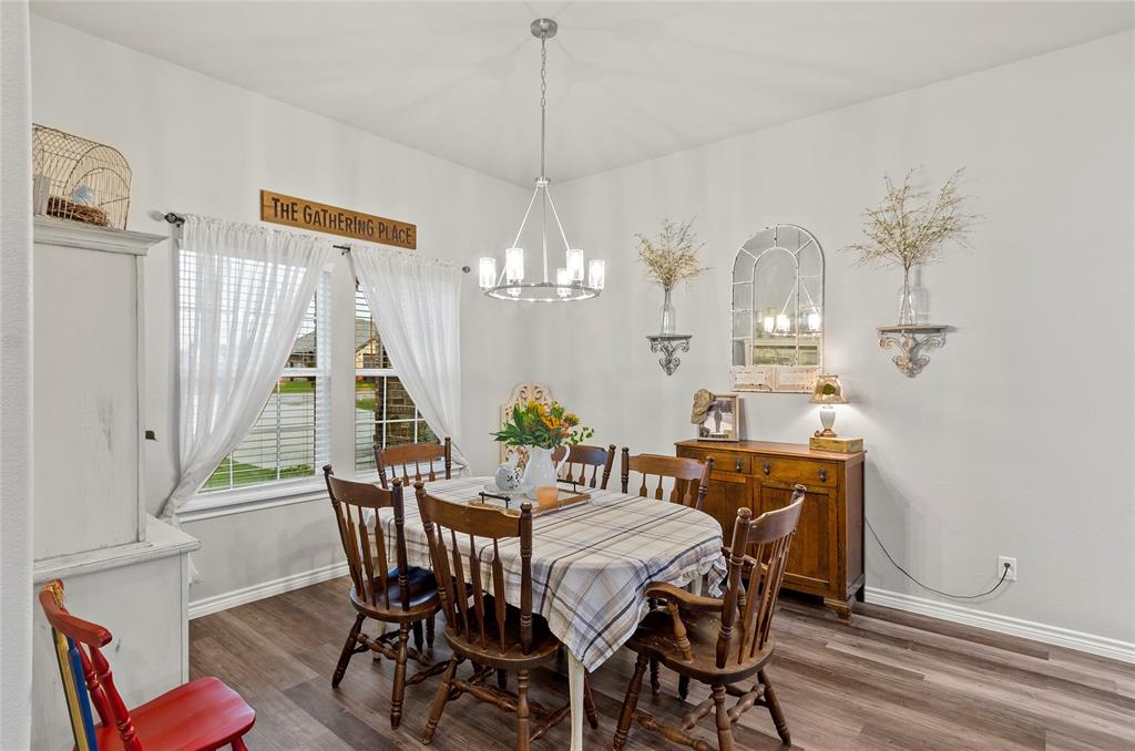 141 Walnut Street Paradise, TX 76073 - Photo 3 of 23 Dining area featuring dark wood finished floors and a chandelier
