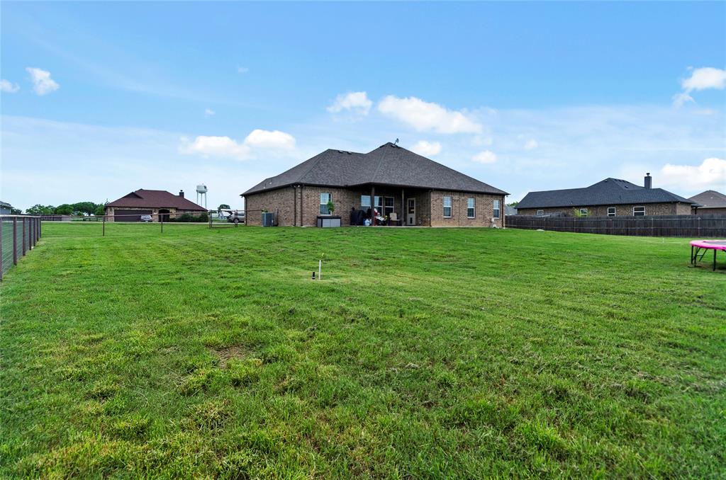 141 Walnut Street Paradise, TX 76073 - Photo 7 of 23 Back of property with a fenced backyard, a patio, and brick siding
