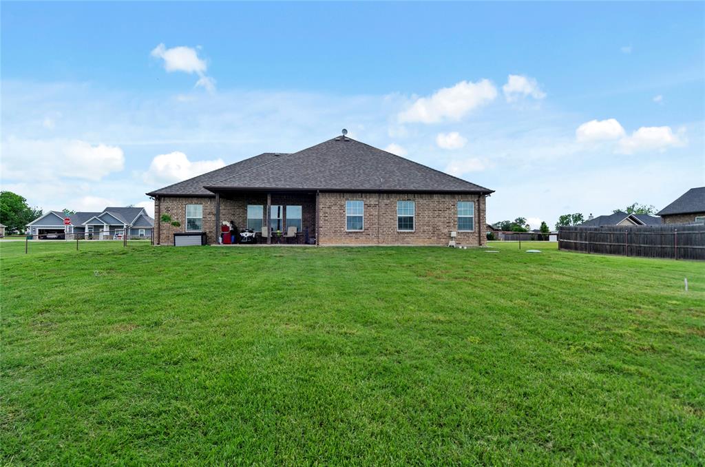 141 Walnut Street Paradise, TX 76073 - Photo 8 of 23 Rear view of house featuring a patio, brick siding, and roof with shingles