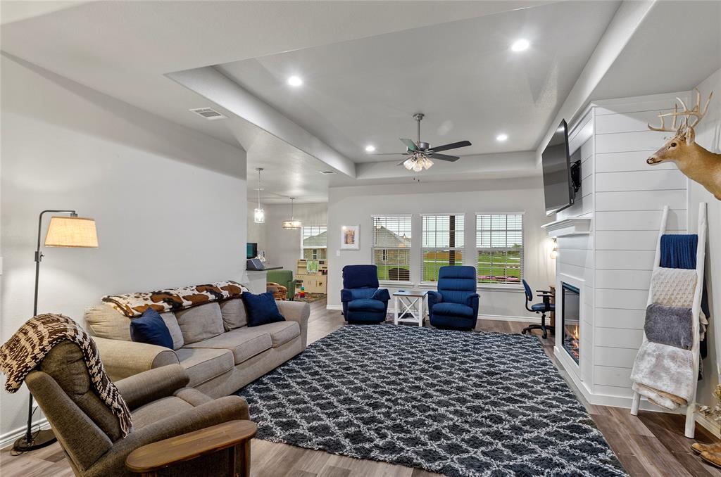 141 Walnut Street Paradise, TX 76073 - Photo 10 of 23 Living area with a raised ceiling, a ceiling fan, recessed lighting, wood finished floors, and a large fireplace